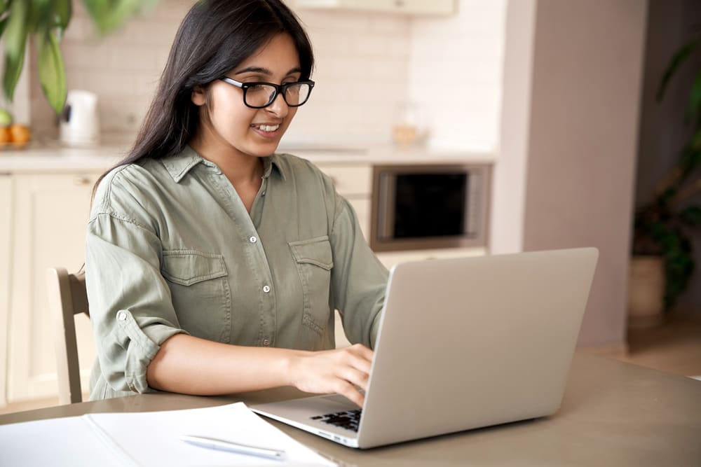 Woman sitting at a table with a laptop